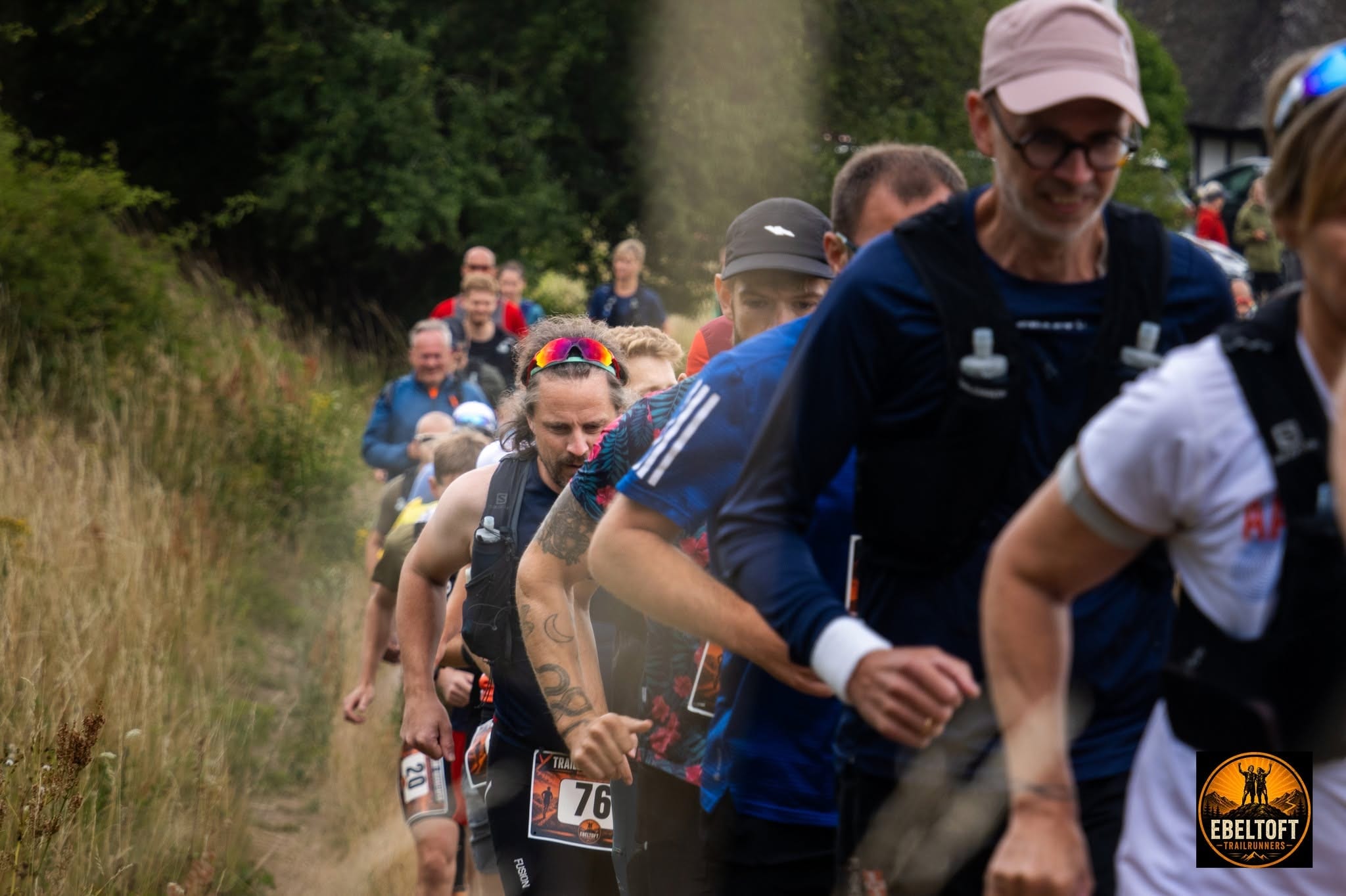 Løbere på smal trailsti langs stendige på Bjergetapens rute i Mols Bjerge